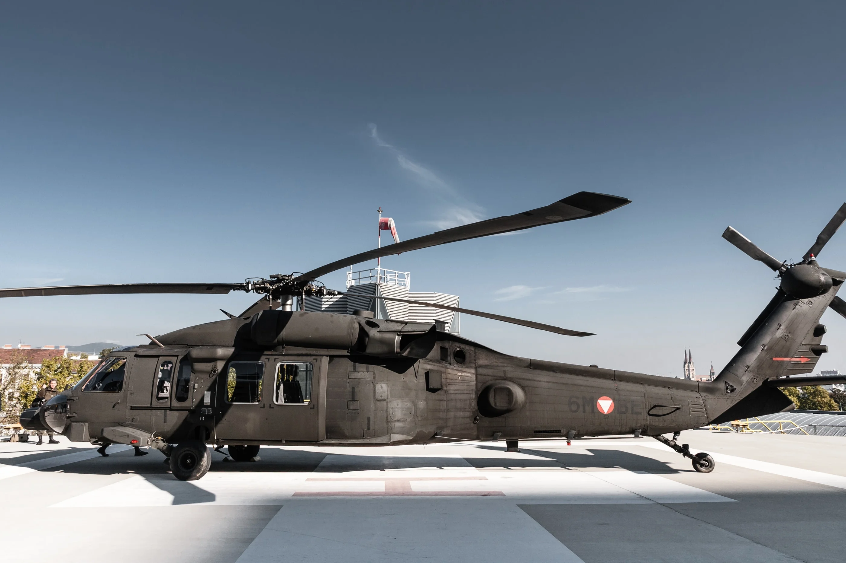 Side view of the Black Hawk on the helipad against a blue sky
