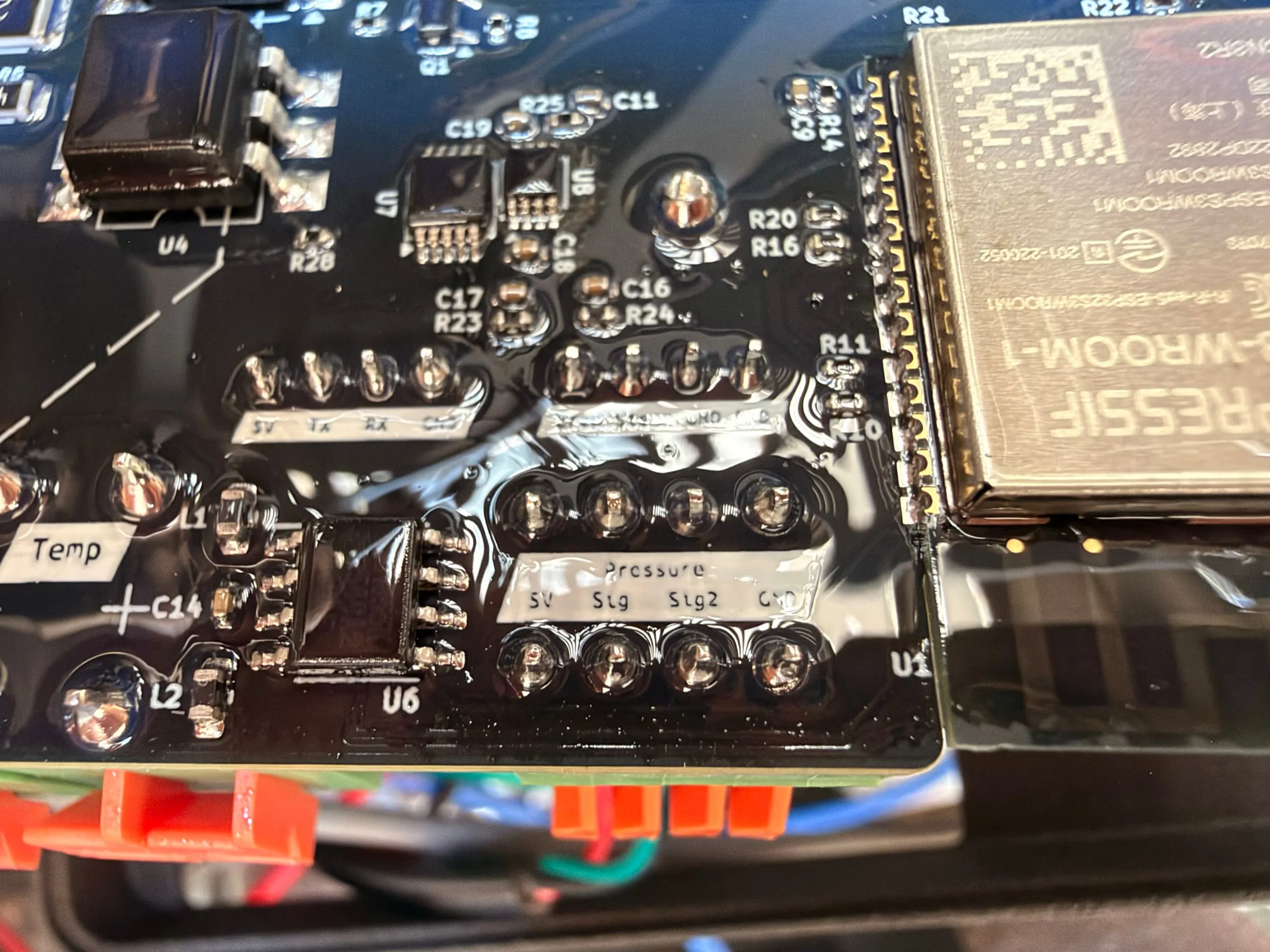Close-up of the GaggiMate Pro board with the ESP32 module and the printed labels of the terminal rows: Temp on the left, Pressure with 5V, Sig, Sig2 and GND on the right