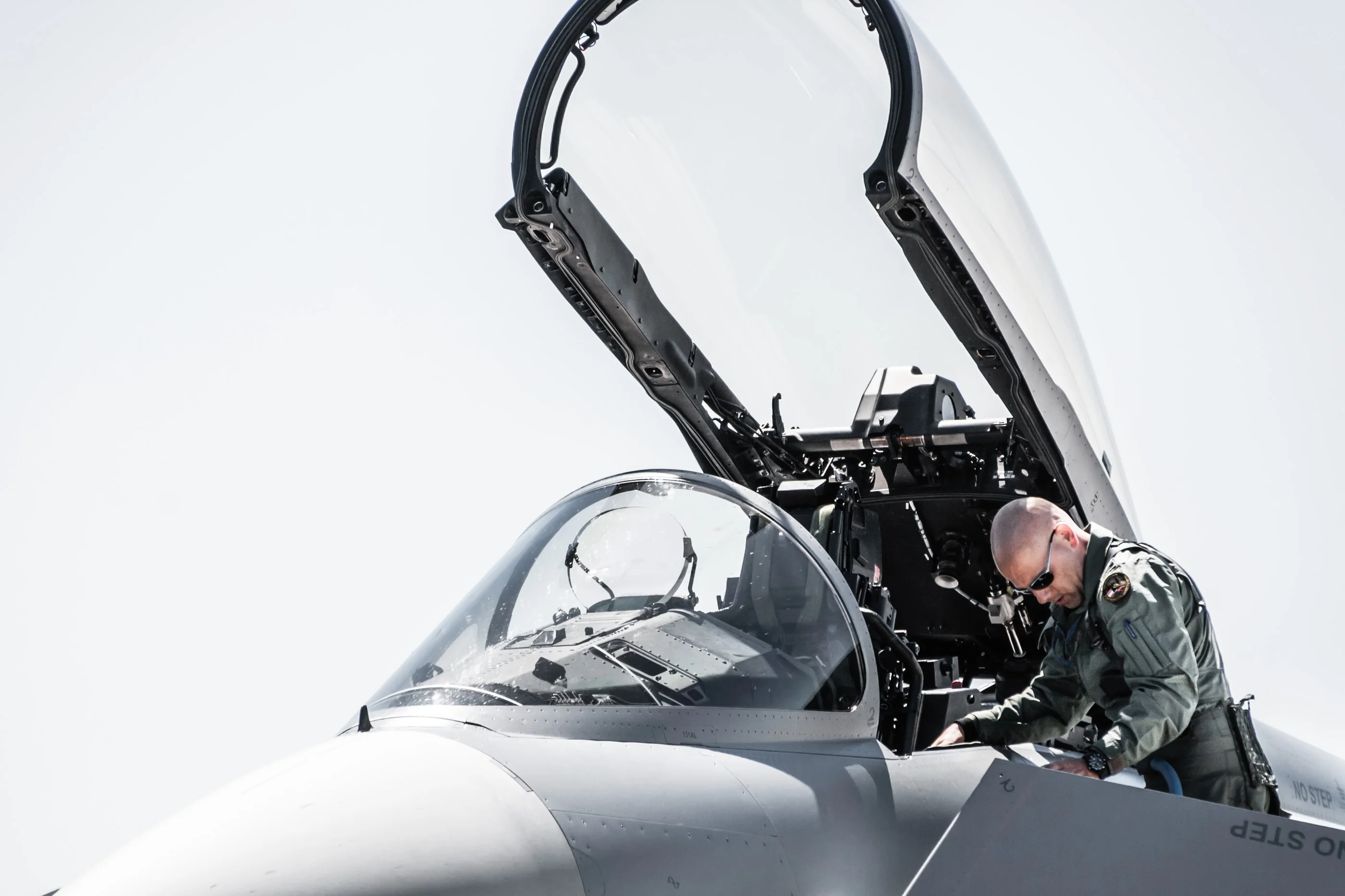 Close-up of a pilot climbing into the Eurofighter cockpit under the open canopy