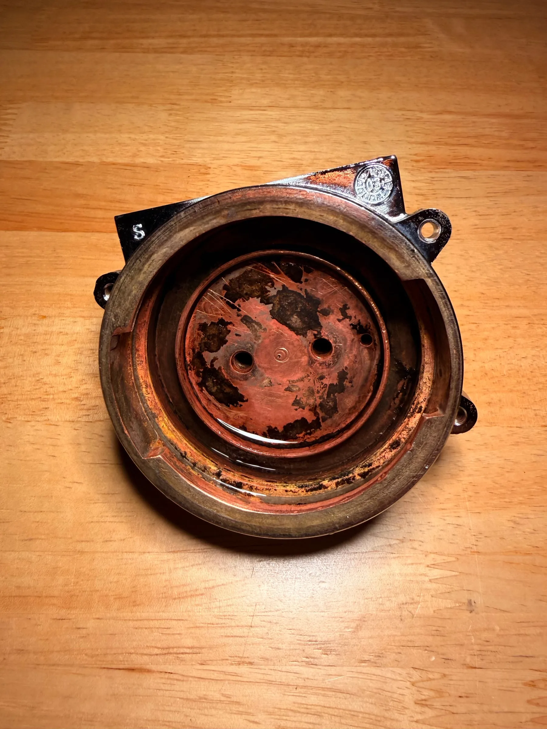 The water side of the group body on the evening of 18 July, after the Cafiza bath: the bowl that feeds the shower screen has gone dark, with black patches on its floor