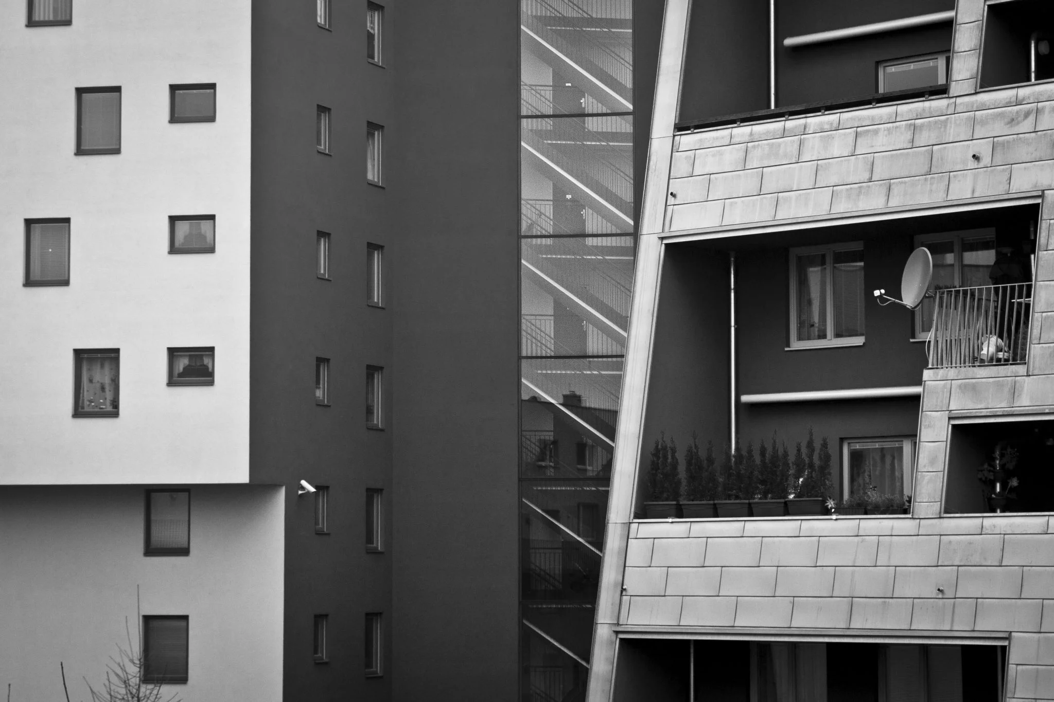 Facades of different apartment blocks meeting, with balconies and a satellite dish