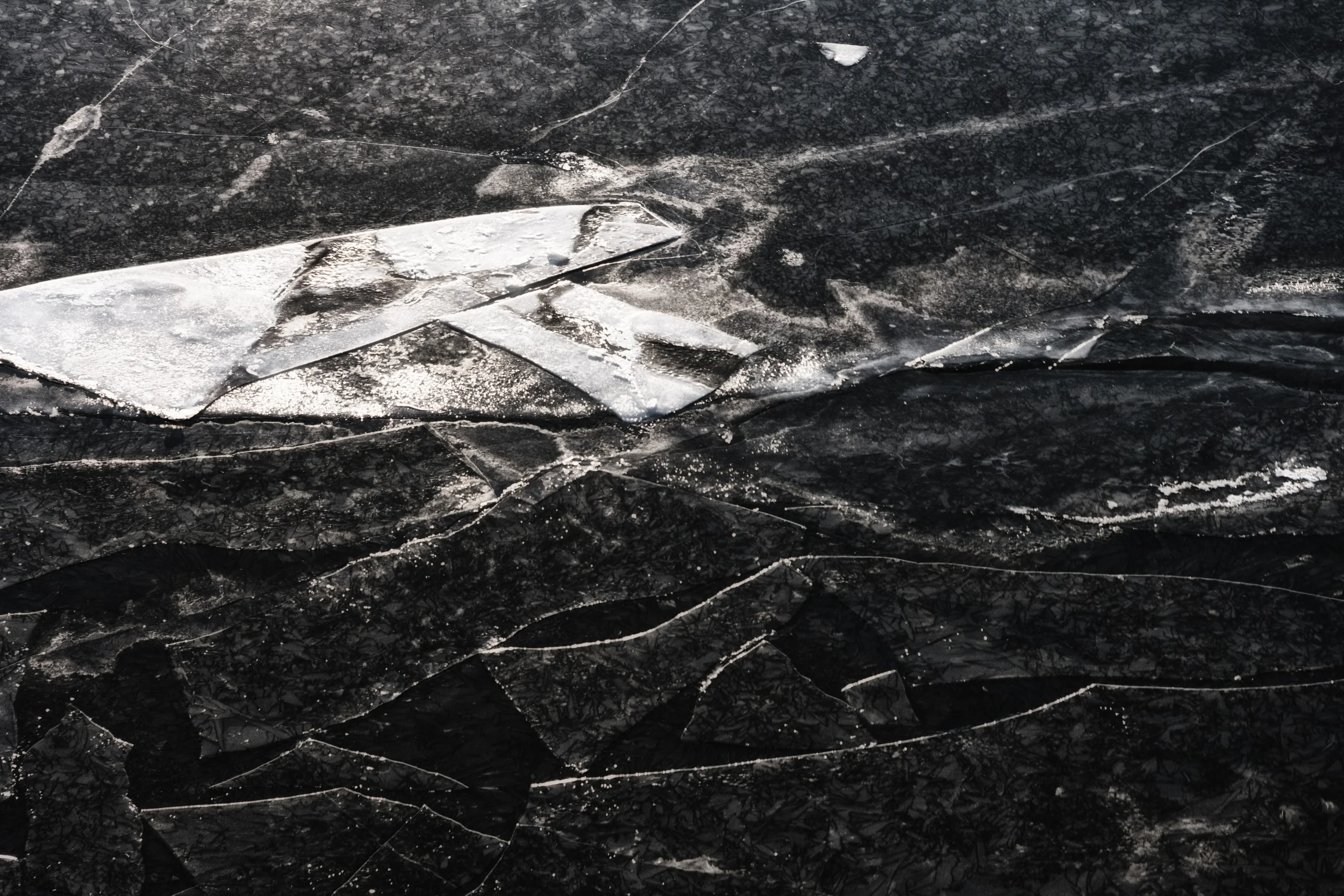 Cracked ice floes on dark water
