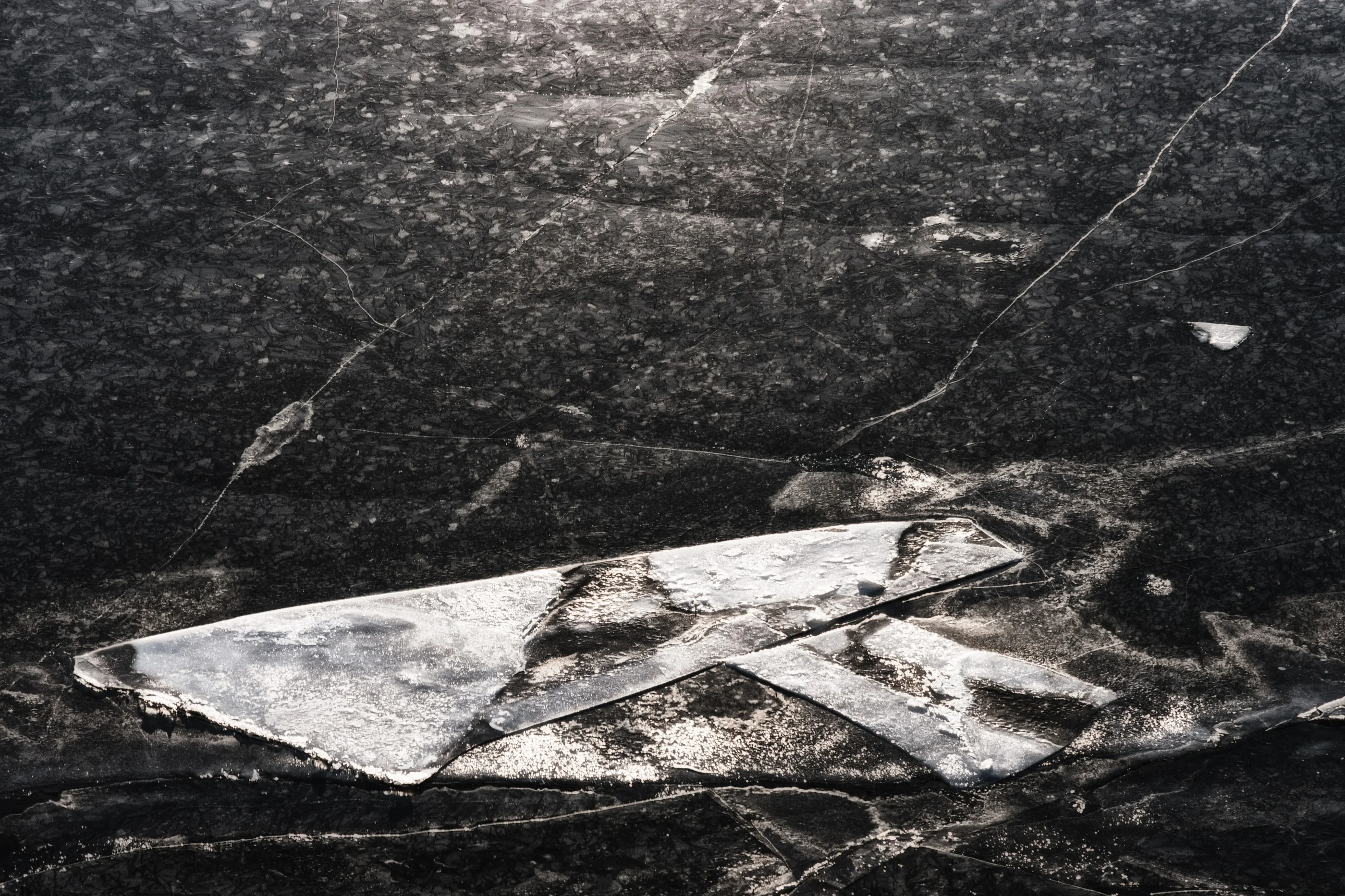 Shards of ice drifting on a dark lake surface