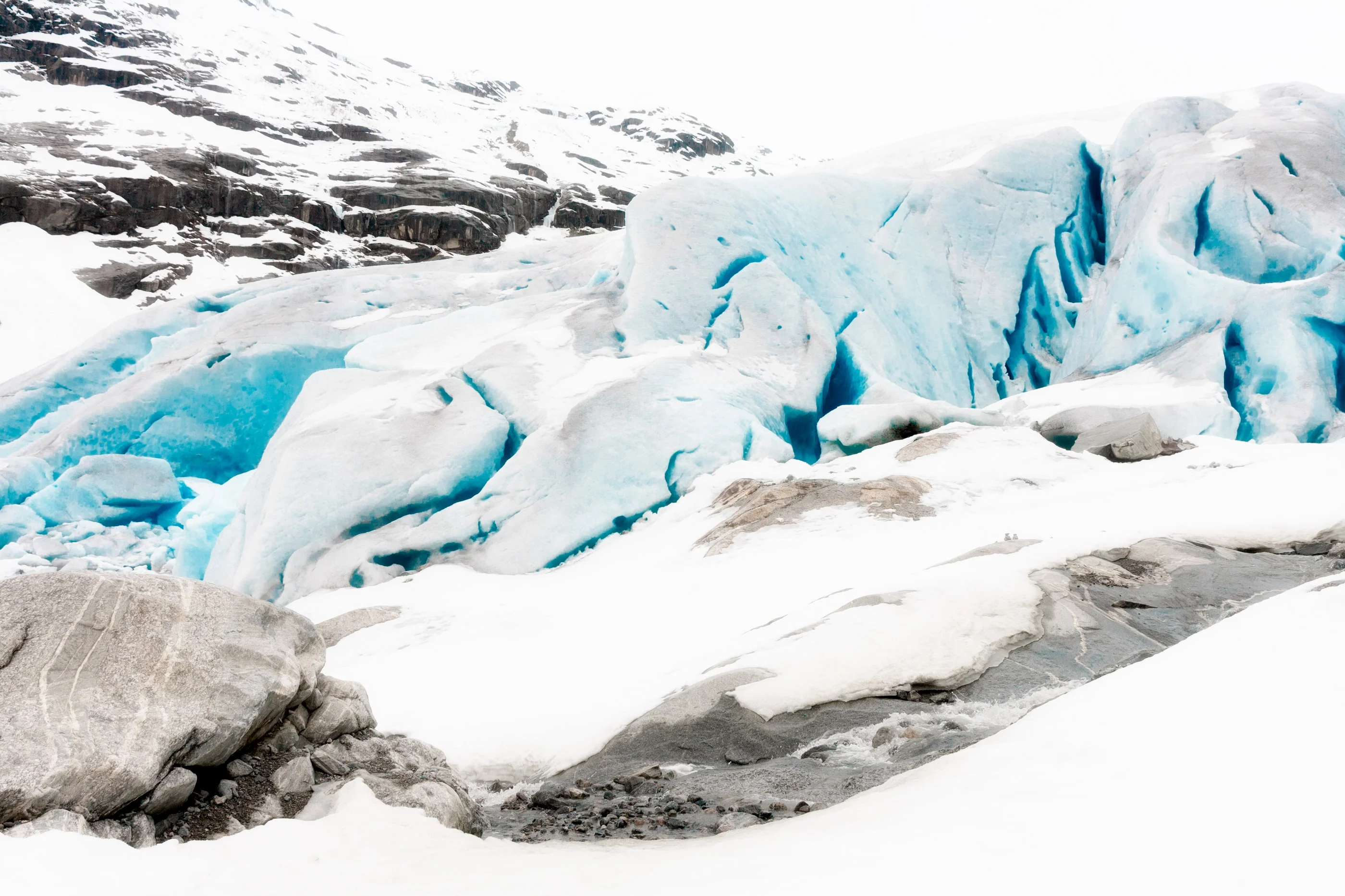 Blue glacier ice above grey boulders