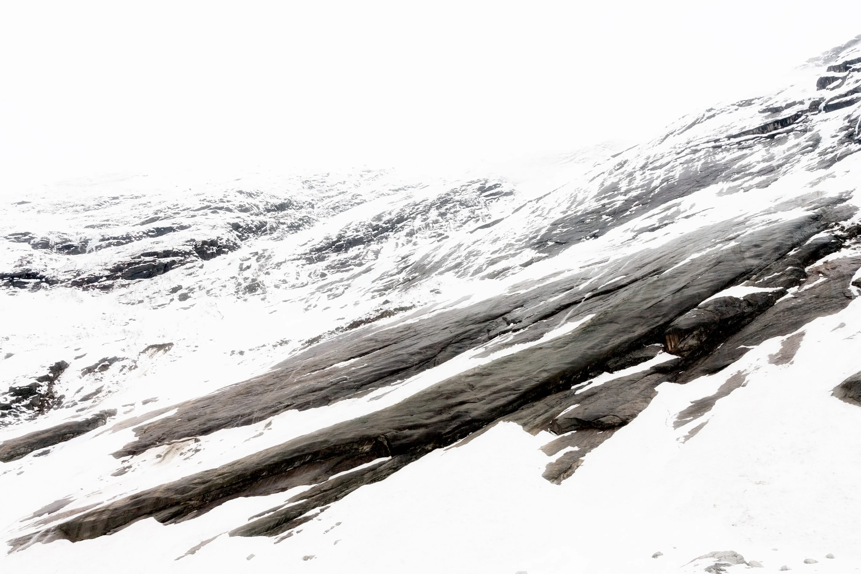 Smooth rock slabs streaked with snow