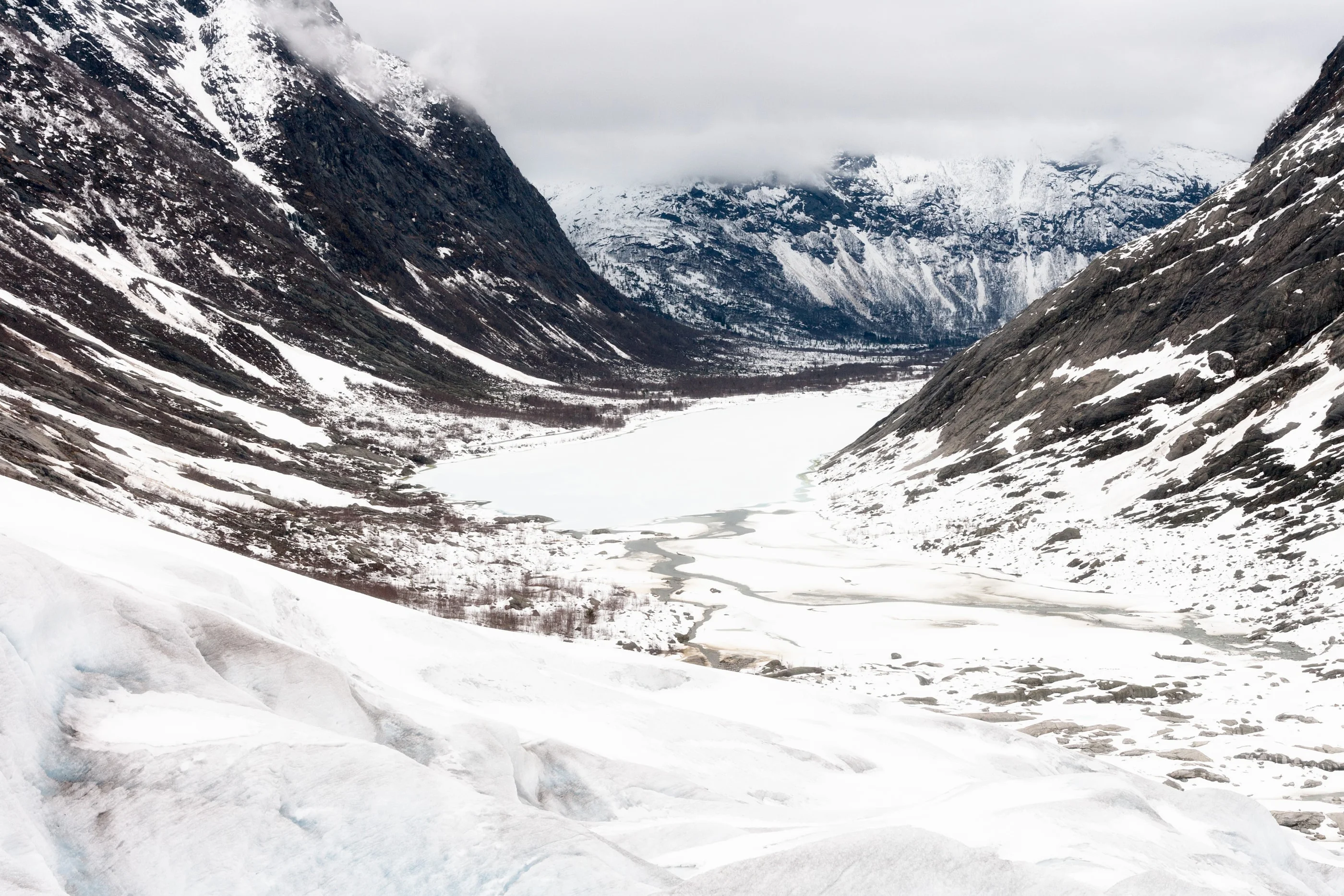 View down the snowy glacier valley between steep mountains