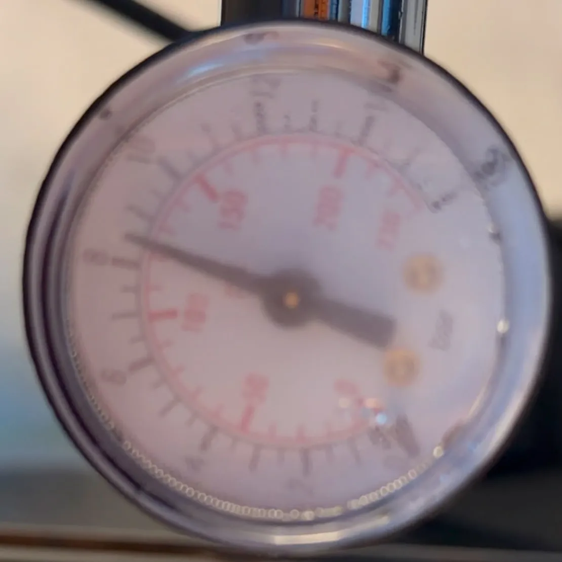 Close-up of the dial of a portafilter pressure gauge, the needle resting between 8 and 9 bar