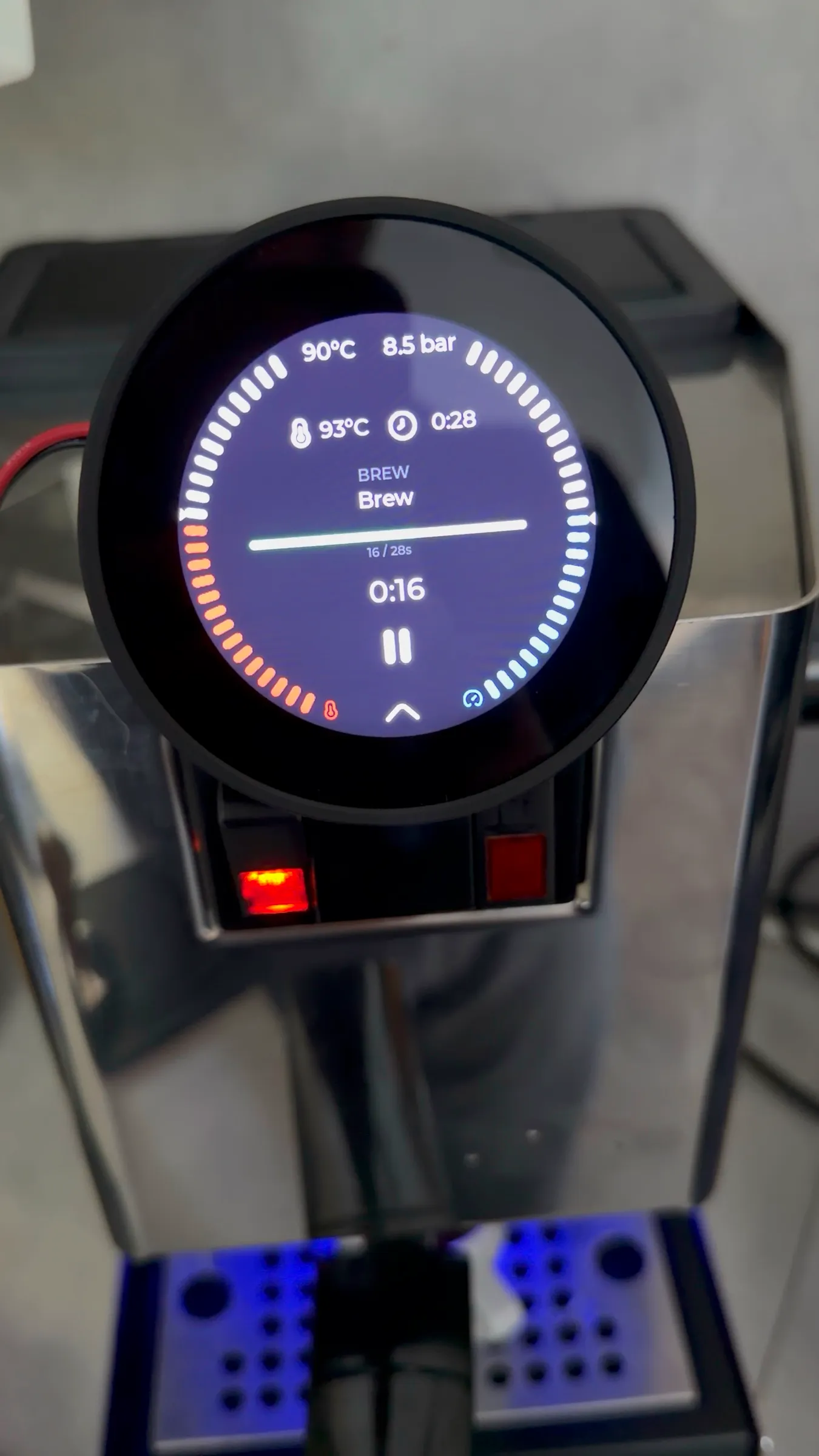 The round display during the shot: 90 degrees and 8.5 bar in the header, the target 93 degrees and 0:28 below, the phase Brew and a timer at 0:16, a progress ring around the edge