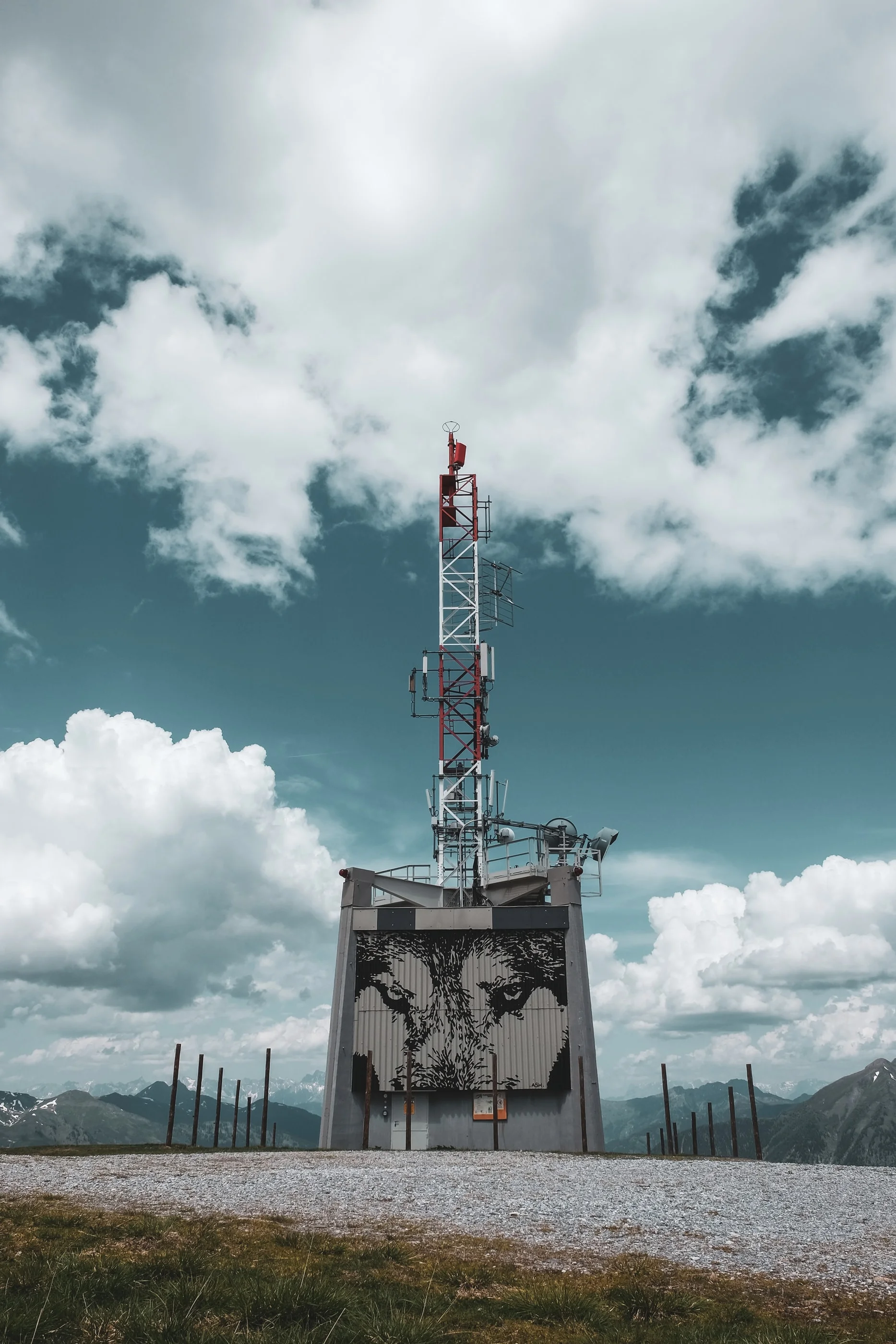 Radio mast on a concrete building against white clouds