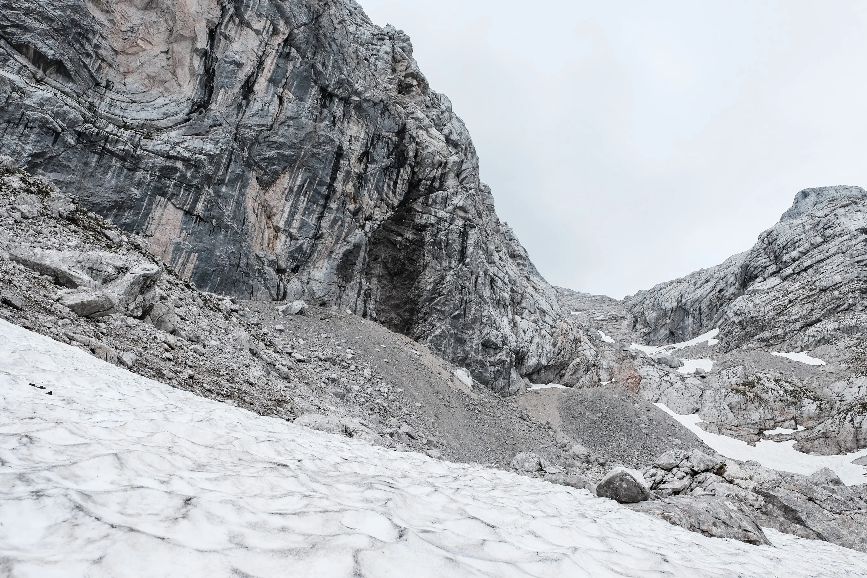 Steep limestone walls above a snowfield
