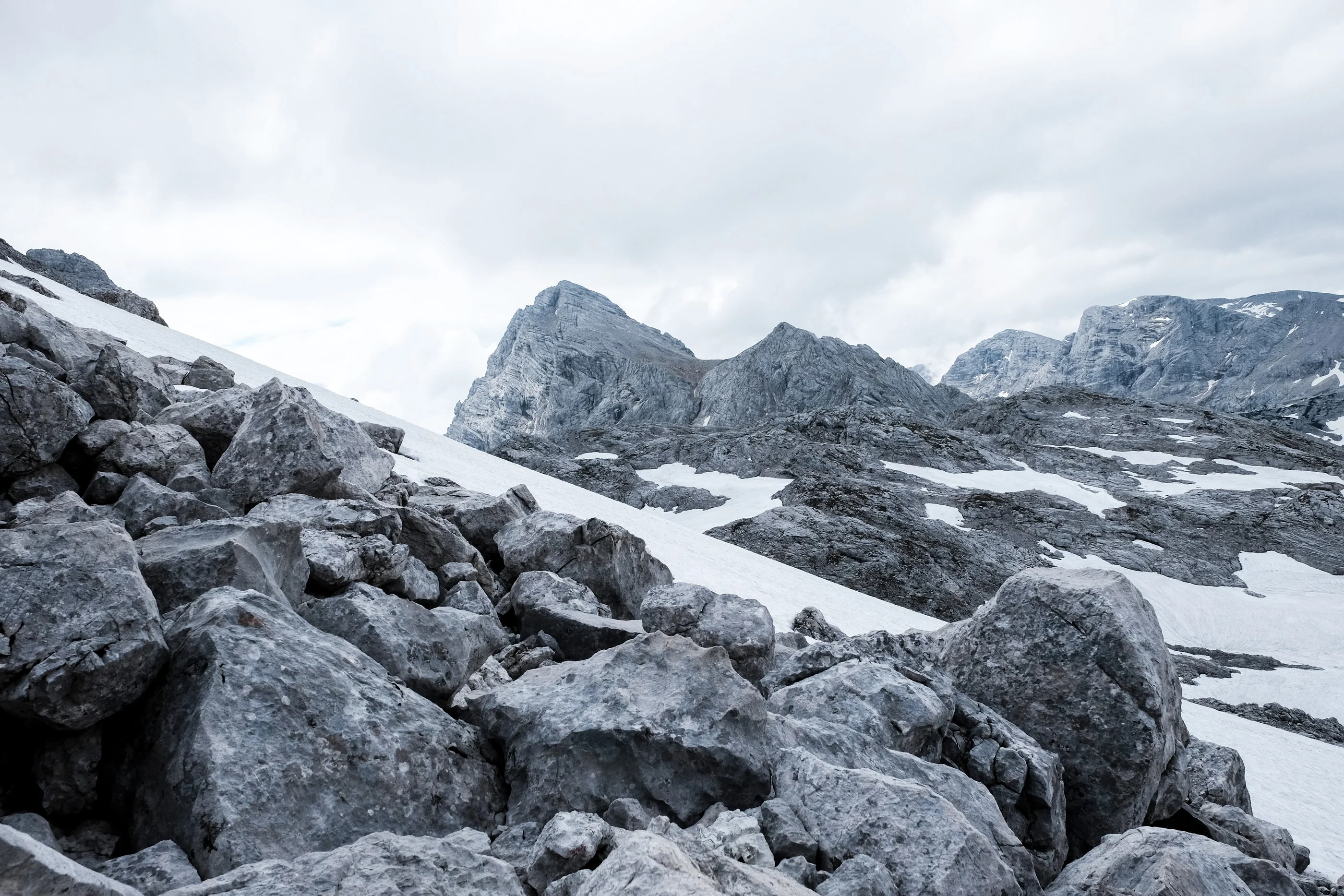 Large boulders in front of jagged grey peaks